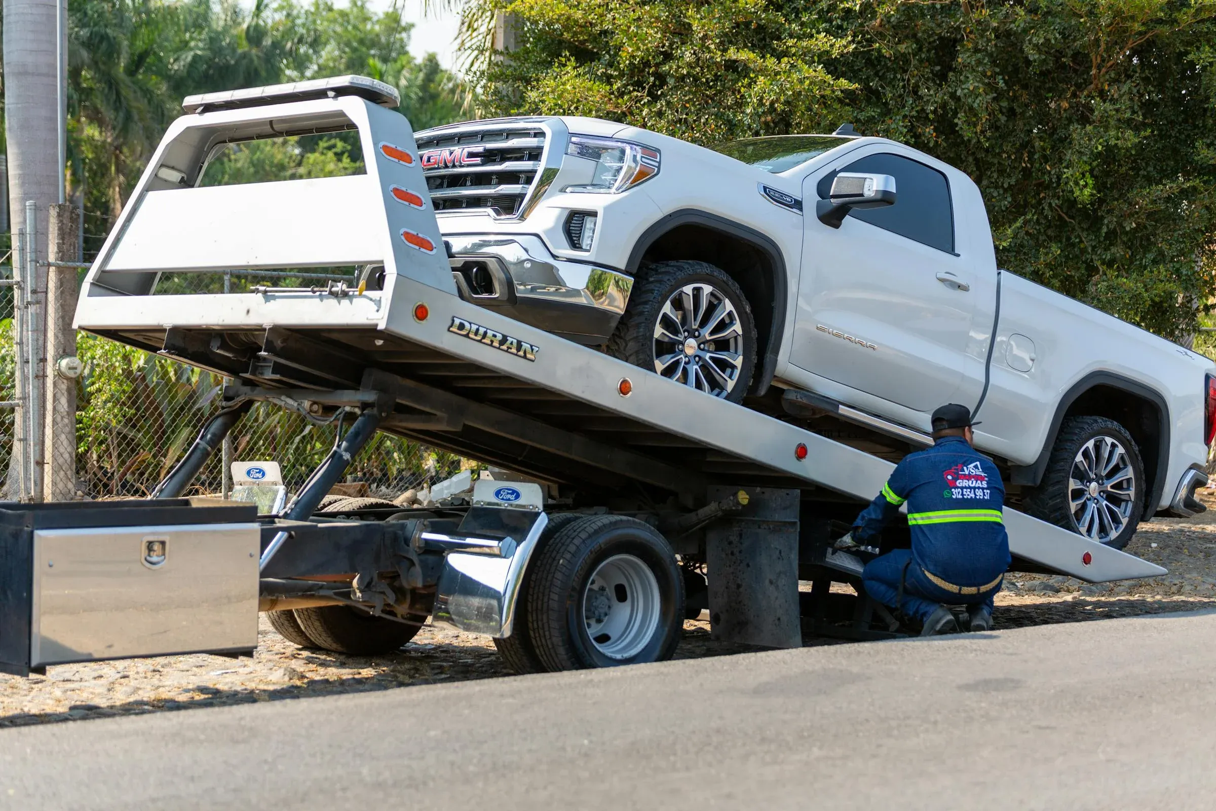 Safelane Towing operator loading a pickup onto a flatbed